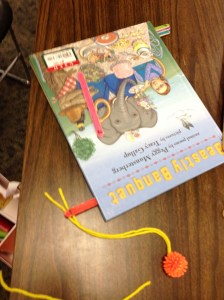 Popsicle sticks as numbered page flippers. Plus, small textured balls to facilitate grasp.